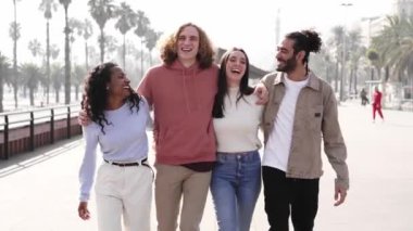 Smiling Friends laughing and having fun together. outdoors. Happy multiethnic young group of people hugging together. High quality photo