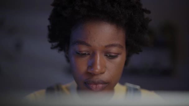 Крупный План Сконцентрированной Молодой Афро Женщины Пялящейся Экран Компьютера Ночью — стоковое видео