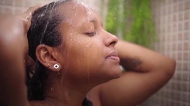 Genç siyah kadın evinde dinlendirici bir duş alıyor. Afro-Amerikalı kadın saçlarını ve kafasını suyla ıslatıyor ve banyoda kendi başının çaresine bakıyor. Sabahları ev içi temizlik kavramı.