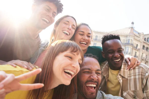 Mutlu, çoklu etnik gruptan arkadaşlar birlikte eğleniyor. Çok ırklı genç meslektaşlar, kentteki bir sokakta selfie için poz veriyorlar. Çok kültürlü dostluk nesli Z konsepti.