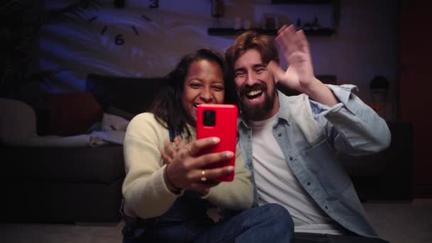 Alegre Pareja Joven Sonriendo Utilizando Teléfono Celular Por Noche Sala — Vídeos de Stock