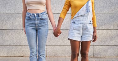 İki tanınmayan çoklu etnik kız arkadaşın el ele tutuşması. Çok kültürlü genç homoseksüel kadınlar açık havada çiftleşiyorlar. Lezbiyen ilişkileri kadın jenerasyonu. Boşluk ve arkaplan kopyala.