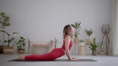 Modern yoga, pilates merkezi ya da evde egzersiz yapan kırmızı spor kıyafetli genç bir kadının tüm vücudu. Sağlıklı yaşam ve kendine dikkat etme pozu veriyor..