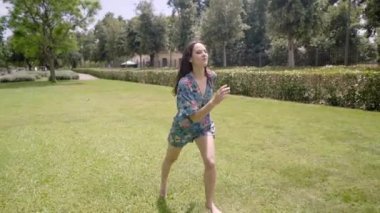 Elbise giyen mutlu özgür kız parkta buğday tarlasında koşuyor. İnsanlar özgürlüğün ve eğlencenin tadını çıkarıyorlar. Kadın dışarıda eğleniyor. Yüksek kaliteli FullHD görüntüler