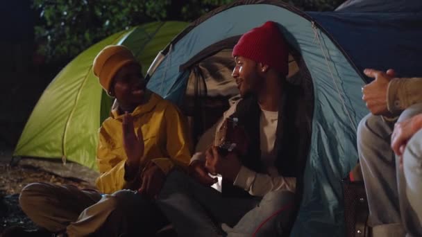 Веселая Молодая Афроамериканская Пара Наслаждается Романтическим Зимним Ночным Лагерем Сидя — стоковое видео