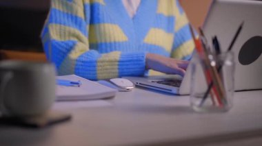 Dizüstü bilgisayarda yazı yazan ve geceleri not defterine yazan kadınların yakın çekimleri. İnternette çalışan tanınmayan genç bir kadın. İş, telekomünikasyon, bilişim uzmanı, öğrenci veya serbest meslek