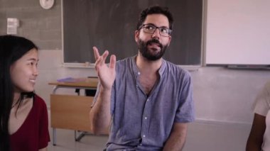 Kafkas hocalarının gözlüklü ve sakallı dersine katılan çeşitli lise öğrencileri sandalyelerde oturup bir çember oluşturuyorlar. Eğitici kavram. 