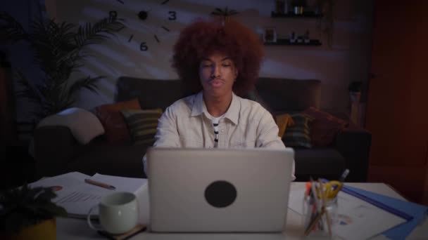 Νεαρός Αφρικανός Που Εργάζεται Συγκεντρώνεται Από Σπίτι Χρησιμοποιώντας Φορητό Υπολογιστή — Αρχείο Βίντεο