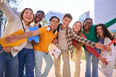 Çok ırklı bir grup genç, selfie çekerken ön kameraya bakıp gülüyor ve dışarıda birlikte eğleniyorlar. Genç öğrenciler sokak şehrindeki arkadaşlarıyla boş zamanlarının tadını çıkarıyorlar.