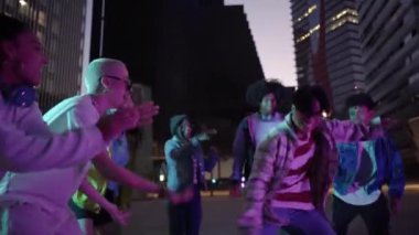 Sokak hip hop dansçıları gibi dans eden genç dansçılar geceleri şehirde serbest dans ediyorlar. Yüksek kalite 4k görüntü