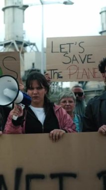 Dikey. Çevre kirliliğini protesto etmek için farklı yaş ve uluslardan gelen bir grup insan. Dünya yanlısı gösteriler iklim değişikliği afişleriyle ciddi bir yüzle kameraya bakıyor