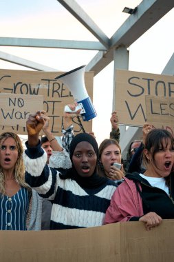 Dikey video. Dünyadaki savaş ve şiddete karşı gösteri yapan çok ırklı genç bir grup. Halk, barış ve savaş karşıtı mesajlar içeren yazılı pankartlarla bir araya geldi.