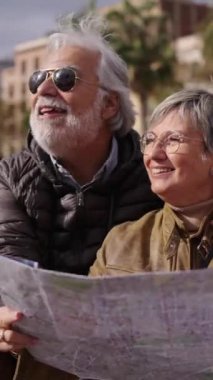 Dikey kıdemli Kafkasyalı çift ellerinde canlı bir seyahat haritası tutarak turistlerin ilgisini çeken yerleri gösteriyorlar. Karı koca şehirde emeklilik tatilinin tadını çıkarıyorlar. Yaşlı turistler. 