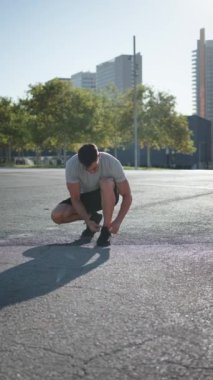 Güneşli bir hafta sonunda dışarı çıkmadan önce spor ayakkabısına ayakkabı bağlayan dikey çekici, olgun bir adam. Orta yaşlı erkek yetişkinler için sağlıklı yaşam tarzı, kilo kaybı, yağ yakma, fitness eğitimi