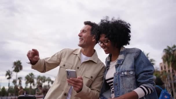 휴가를 즐기는 도시에서 전화를 말하는 성숙한 다인종 남편과 아내가 관심의 — 비디오