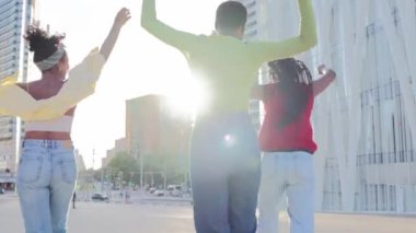 Üç heyecanlı siyahi kadın grubu dans ediyor, zıplıyor ve birlikte eğleniyorlar. Şehir caddesinde boş zamanlarının tadını çıkarıyorlar. Afro-Amerikalı güzel kadınlar el ele tutuşup arkadaşlığı kutluyor. Yavaş çekim