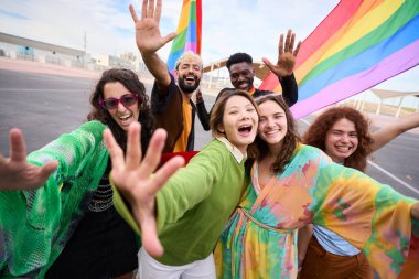 Renkli insanlarla dolu bir kalabalık gökkuşağı bayrağıyla selfie çektirmek için gülümsüyor. Gurur gününde eğlencenin ve seyahatin tadını çıkarıyorlar. LGBT 'nin çeşitli insanları toplum için birleşti