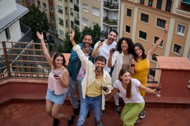 Şarap kadehli bir grup arkadaş, gülümsüyor ve pencerelerinden manzarası olan bir çatı katında eğlenceli bir anı paylaşıyorlar. Eğlence ve kahkahalarla dolu bir gezi.
