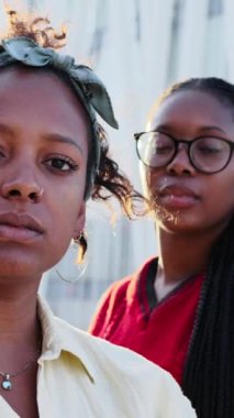 Dikey portre, kameraya ciddi bakan üç Afro-Amerikan kadını. Kapitalist kadınlar güçlü ve açık havada zorlayıcı ifadeleri var. Feministler ve ırk hakları kavramı