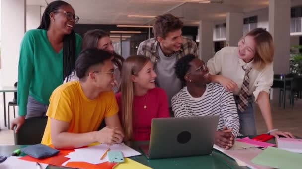 在校园内的自助餐厅里 一群快乐的年轻大学生和他的同学一起在一个项目中使用笔记本电脑 笑着让多种族的人一起在教学楼里学习 — 图库视频影像