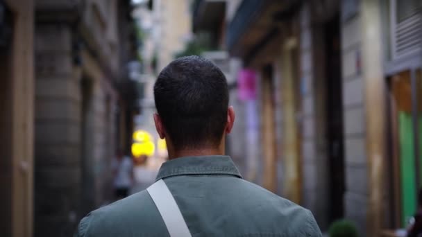 在巴塞罗那的旅游购物街 后视镜下 白人年轻的成年男子高兴地看着灯火通明的橱窗 在欧洲城市的街道上 身穿时髦衣服 留着胡子的男子在夜间漫步 — 图库视频影像