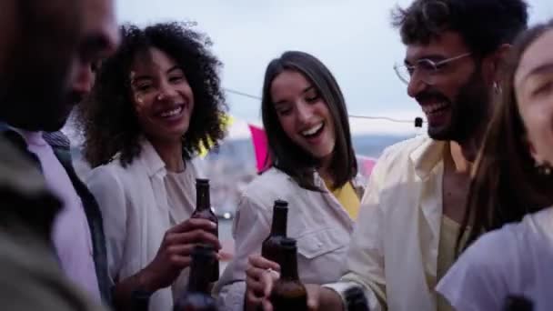 快乐的多种族年轻人举着啤酒瓶庆祝夏天的户外跳舞和欢笑 兴奋的团体千年快乐的朋友一起在天台派对上享受夕阳西下 — 图库视频影像
