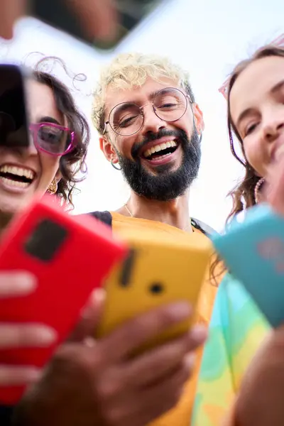 A group of happy people is celebrating and sharing a fun moment using mobile with their colorful cell phones, smiling and making gestures. Youth people o millennial generation addicted to technology