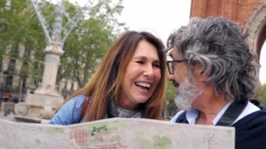 Yurtdışında gülen yetişkin bir çift Avrupa şehrini ziyaret etmek için yerel bir harita kullanıyor. Kıdemli gezginler birlikte konuşuyor. Emekli evli adam ve kadın hafta sonu kaçamağının tadını çıkarın. Olgun insanlarda turizm