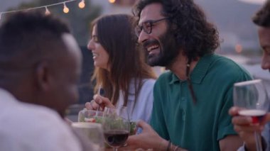 Gülümseyen insanlar arkadaşlarıyla mangal ve içecek buluşmalarında eğleniyorlar. Gün batımında terasta yiyip içen çift. Dışarıda bir yemeği kutlayan bir grup çok ırklı arkadaş.