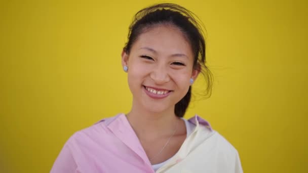 Porträt Einer Jungen Asiatin Mit Strahlendem Lächeln Die Vor Gelbem — Stockvideo