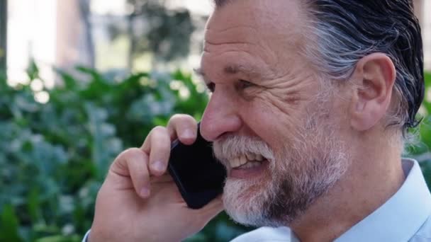 办公室外的成年高加索商人在手机上静静地谈着话 高级专业人员在户外运动时穿正装 成熟的灰头发胡子企业家喜欢休息工作 — 图库视频影像