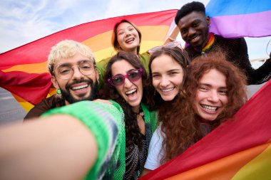 Gökkuşağı bayraklı selfie için renkli gülümseyen mutlu insanlardan oluşan bir kalabalık. Eğlencelerini ve boş zamanlarını yakalıyorlar. Gay ve lezbiyen arkadaşlar eşcinseller geçit töreninde beraberler. LGBT kavramı