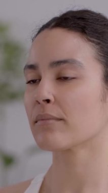 Dikey. Gülümsemeyi seven genç Latin bir kadın, evde yoga egzersizleri yapıyor. Mutlu insanlar sınıfta meditasyon yapıyor ve konsantre oluyorlar. Sağlıklı kadın yaşam tarzı ve sağlık