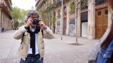 Yaşlı gri adam hatıra fotoğrafı çekiyor. Barselona caddesinde tanınmayacak kadar olgun bir kadın. Kafkasyalı emekli turistler Avrupa 'da tatilin tadını çıkarıyorlar. Yetişkin çağında aşk ve romantik seyahat