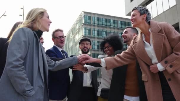 一群穿着正式服装的兴高采烈的商人聚集在一起 互相微笑 手拉手 以此来表示团结 并在正式场合庆祝成功 — 图库视频影像