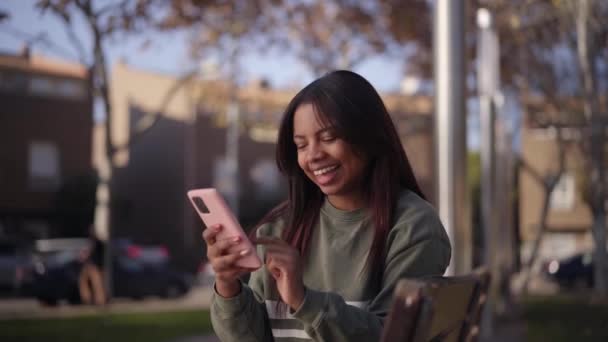 Nastoletnia Latynoska Śmiesznie Patrzy Telefon Szczęśliwa Młoda Kobieta Siedząca Parku — Wideo stockowe