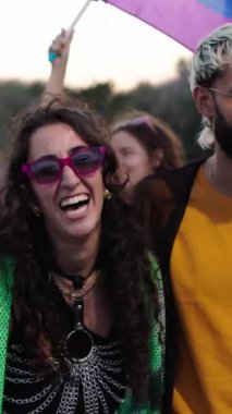 Bir grup LGBT 'linin dikey hâli, neşeli ve mutlu bir etkinliğin tadını çıkaran renkli gökkuşağı bayrakları taşıyan gay günü geçit töreninde sokakta boş boş yürüyor. Çeşitli erkek ve kadınlar birlikte çalışır.