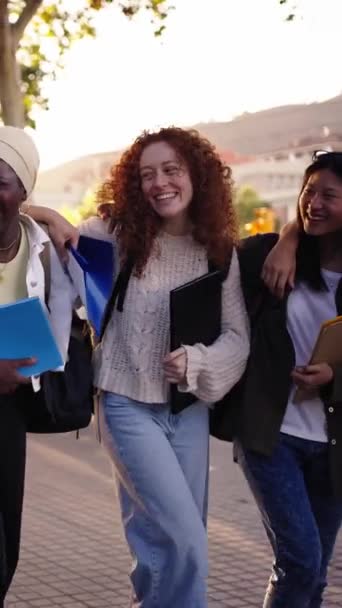 一个多种族的年轻快乐学生在户外散步和聊天的垂直视频 不同的大学生朋友 课后背着背包和书本在校园公园里散步 — 图库视频影像