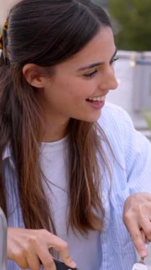 Dikey. Gün batımında masada yemek servisi yapan gülümseyen adam. Mutlu bir kadın partide arkadaşlarıyla yemek yiyor ve sohbet ediyor terasta toplanıyor dışarıda barbekü yemeği yiyor. Milenyum sosyal ilişkileri