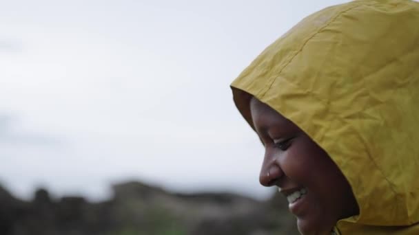Junge Lächelnde Afroamerikanerin Gelbem Regenmantel Einer Natürlichen Landschaft Während Sie — Stockvideo