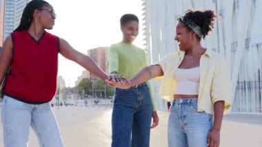 Bir grup mutlu ve gülümseyen Afrikalı Amerikalı sadece el ele tutuşan ve onları kutlayan kadınlar. Siyahi kadınlar, sokak şehrinde boş zamanlarının keyfini çıkarırken çok heyecanlılar. Motivasyon ekibi
