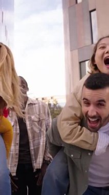 Çok ırklı genç arkadaşlardan oluşan dikey grup şehirde gülücükler ve kahkahalar paylaşarak eğleniyor. İnsanlar birlikte dışarıda neşeli bir kamera ile sırtına biniyorlar. Arkadaşlık ve toplum kavramı