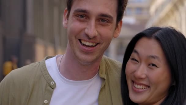多种族的一对相爱的好夫妇 看着摄像机 带着深情的才华拥抱在一起 年轻的亚洲女子与白种人快乐的男子在户外热烈拥抱时的亲密合影 — 图库视频影像