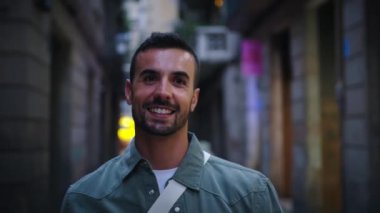 Ön manzara, Madrid 'de turist alışveriş caddesinde aydınlanmış bir gösteride mutlu görünen beyaz bir erkek. Şık giyimli sakallı adam Avrupa şehrinin caddesinde geceleri dolaşıyor.