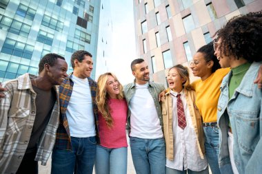 Genç Avrupalı öğrenci arkadaşlar birlikte eğleniyor ve dışarıda sarılıyorlar. Birleşmiş Nesiller Z insanları, şehir sokaklarında kucaklaşarak topluluk içinde zaman geçiriyorlar..
