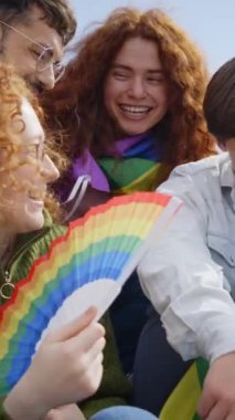 Dikey. Gruptaki çok ırklı, heyecanlı insanlar eşcinsellerin gurur gününü kutlamak için toplandılar. Çeşitli neşeli arkadaşlar LGBT partisinde gökkuşağı bayraklarıyla birlikte eğleniyorlar. Z jenerasyonu ve cinsel özgürlük.