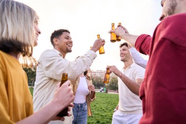 Birayla kadeh kaldıran bir grup genç arkadaş parkın dışındaki bir partide eğleniyorlar. Kutlamanın tadını çıkarıyorlar. İnsanlar dans edip gülerken yaz günbatımı çimlerin üzerinde. Tatilleri severler..