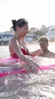 Mayolu mutlu genç bir arkadaş grubu, suyun içindeki su oyunlarıdır. Sahilde gülümseyen ve eğlenen. İyi anılar ve Z jenerasyonu dostluk insanları yaz tatilinin tadını çıkarıyorlar.