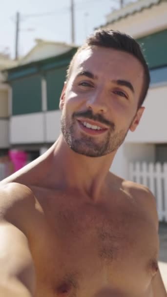 一个有魅力的年轻白种人微笑男子的垂直视频电话在海滩上用社交媒体拍了个自拍 在暑假期间 他一边享受假期 一边对着相机挥挥手 并亲吻对方 — 图库视频影像