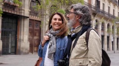 Mutlu yetişkin Kafkasyalı çift el ele tutuşup İspanya 'nın turistik sokaklarına bakıyorlar. Son sınıf evliliği turizm tatilinde sakince yürüyor. Romantik ilişkiler ve emeklilik seyahati 